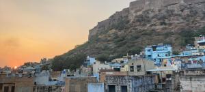 a group of buildings on a hill with a mountain at The Brahmin's Homestay in Jodhpur