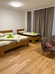 a room with two beds and a table and a chair at Apartmány Skalica in Skalica +75 photos