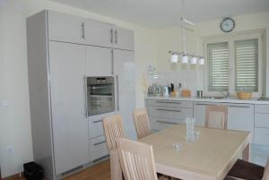a kitchen with a table with chairs and a clock on the wall at Apartments Lumbarda Beach in Lumbarda