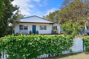 a white house with a white fence at Number Five Beach House in Callala Beach