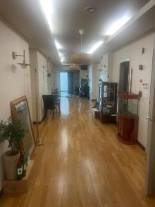 a living room with a hard wood floor and a room with a table at Lyndon Guesthouse in Jeju +103 photos