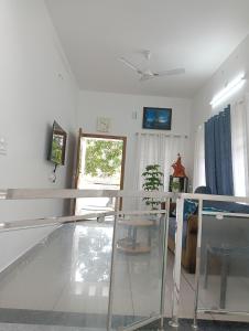 a living room with a glass table and a window at Rohini Homestay & Serviced Villa-Explore Alleppy in Alleppey