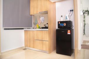 a small kitchen with a refrigerator and a microwave at -Mount Austin IKEA, AEON 10mins -Pool View- B215 in Johor Bahru