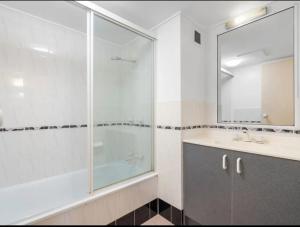un bagno con doccia, lavandino e specchio di A 3 bedders close to everything a Brisbane
