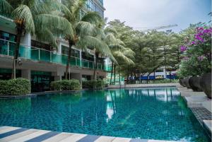 a swimming pool in front of a building with palm trees at -Mount Austin IKEA, AEON 10mins -Pool View- B215 in Johor Bahru