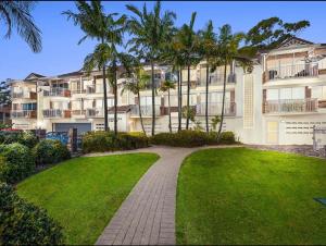 una passerella di fronte a un edificio con palme di A 3 bedders close to everything a Brisbane