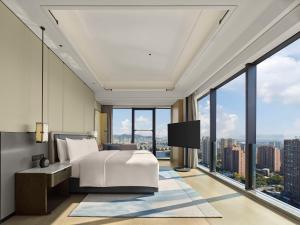 a bedroom with a bed and large windows at Hilton Yuyao in Yuyao