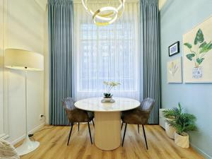 Un comedor con mesa y sillas y una ventana. en Modern Elegance - CBD Luxury 1BR on Central Queen St, en Auckland