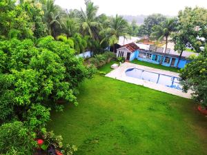 an aerial view of a house and a yard with a swimming pool at ecr resorts- pleasant stay farmhouse in Sadras