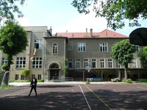 a man walking in front of a large building at Pension zur Wartburg in Görlitz