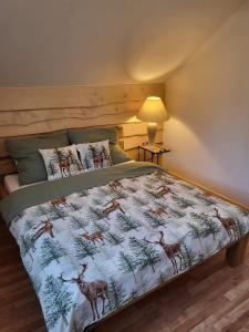 a bedroom with a bed with a deer print on it at domek alepjski in Rymanów-Zdrój +3 photos