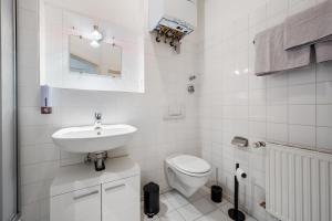 a white bathroom with a sink and a toilet at Apartment 5 min zur Fußgängerzone in Wiesbaden +21 photos