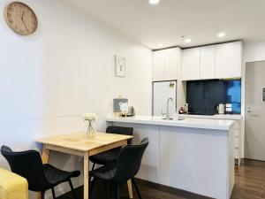 奥克兰Modern 2 Bedroom Beside Skytower & Queen St in The Heart of CBD的带桌椅和钟的厨房