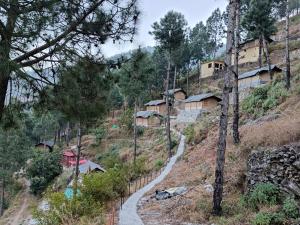 a village on a hill with a winding road at Jaseelo Camps near Tehri Lake in Chamba