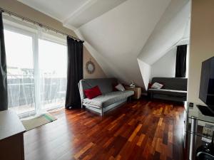 a living room with a couch and a large window at Apartament Topolowa 2 in Dębki