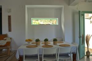a white dining room with a white table and chairs at Villa Aquilo in Megali Ammos