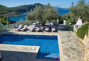 a pool with lounge chairs and a view of the water at Villa Aquilo in Megali Ammos