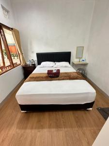 a bedroom with a large bed with a purse on it at Vallari Besakih Homestay in Besakih