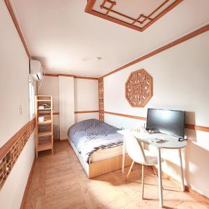 a bedroom with a desk and a bed with a computer at Huesik Guesthouse in Seoul