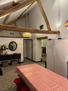 a kitchen with a refrigerator and a table in a room at PARENTHESE 30 COUCHAGES SUR 2 GITES PISCINE 1H30 Paris CAMPAGNE CHIC in Conflans-sur-Loing