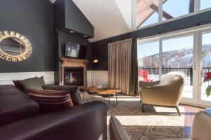 a living room with a couch and chairs and a fireplace at Domaine Nymark in Saint-Sauveur-des-Monts