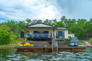 a house on a dock on a body of water at Bungalow 58 Lake Bennett Darwin in Lake Bennett