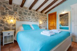 a bedroom with a blue bed with towels on it at Mas Fullat casa rural Alforja in Alforja
