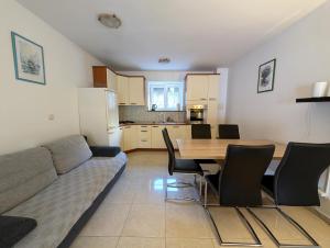 a living room with a couch and a table with chairs at APARTMAN 1 Istočna Gomilica in Tisno