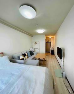 a bedroom with a bed and a couch and a table at ShinjukuFleur-309 in Tokyo