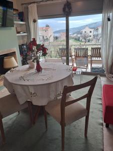 a dining room table with a vase of flowers on it at Sunset at Cape Sounio in Sounio