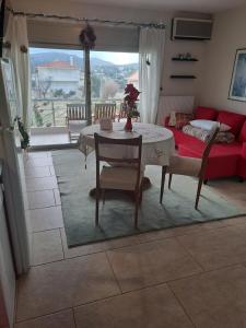a living room with a table and a red couch at Sunset at Cape Sounio in Sounio