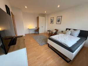 a bedroom with a bed and a flat screen tv at FeWo am Baunsberg in Baunatal
