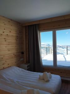 Un dormitorio con una cama y una ventana grande. en Apartamentos Montreal premium, en Sierra Nevada