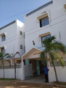 a man standing in front of a white building at G-wel's Sun Sweet Apartment in Mombasa