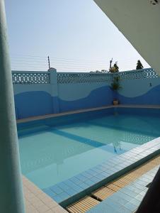 a swimming pool with a blue wall at G-wel's Sun Sweet Apartment in Mombasa