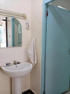 a bathroom with a sink and a mirror at G-wel's Sun Sweet Apartment in Mombasa