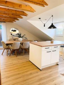 a kitchen with a white island and a table at Das Coming Home in Baunatal in Baunatal +18 photos