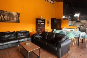 a living room with a black leather couch and a table at Amama in Carranza +18 photos