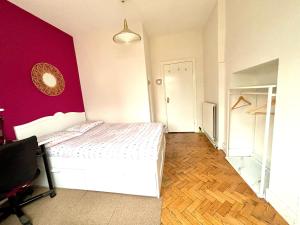 a bedroom with a white bed and a red wall at Winton house home stay in Bournemouth +23 photos