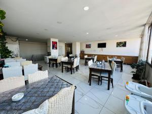 ein Esszimmer mit Tischen und Stühlen und einem Fernseher in der Unterkunft Toprak Hotel in Van