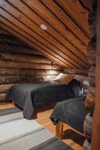 a room with two beds in a log cabin at Rukan Talvikota in Kuusamo +19 photos