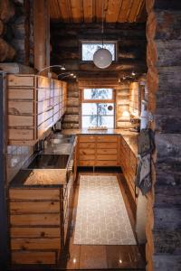a kitchen in a log cabin with a window at Rukan Talvikota in Kuusamo