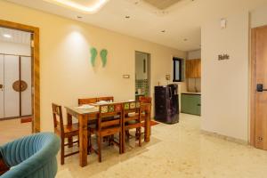 a kitchen and dining room with a table and chairs at ELIVAAS 1 BHK with Rooftop Pool - Kamerios Skye in Nerul