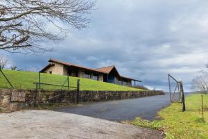 a house on top of a hill with a fence at Aitxitxe in Carranza