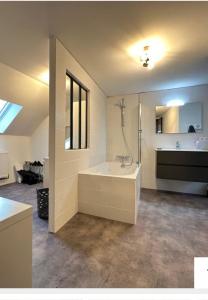 a large bathroom with a tub and a sink at Maison Bourgeoise Élégante pour 10 Pers Confort Moderne & Charme à Montrichard in Montrichard