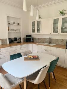 a white kitchen with a white table and chairs at Maison Bourgeoise Élégante pour 10 Pers Confort Moderne & Charme à Montrichard in Montrichard