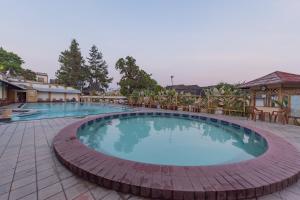 a large swimming pool with chairs around it at Urbanview Hotel Crown Tasikmalaya by RedDoorz in Tasikmalaya