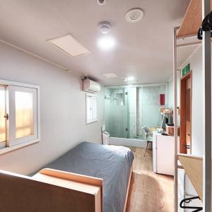 a bedroom with a bed and a bathroom with a shower at Huesik Guesthouse in Seoul