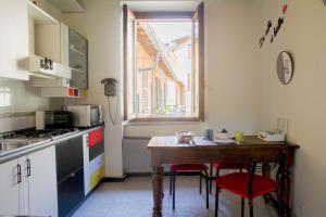 małą kuchnię z drewnianym stołem i oknem w obiekcie BnButler - Navigli Apartment - Vicolo Lavandai w Mediolanie +18 zdjęć