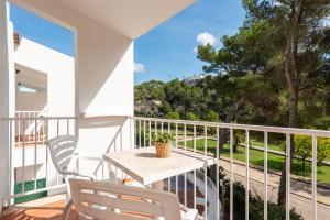 a balcony with a table and chairs and a view at Apartamentos alta galdana playa in Cala Galdana